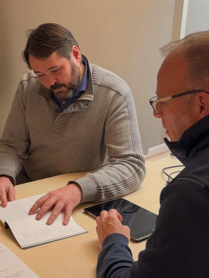 Homme montrant un carnet à un autre homme